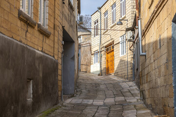 Old shell houses. The masonry walls of the house are made of limestone blocks. The streets are paved with blocks of natural stone. The quarters of the ancient city in the mountains.