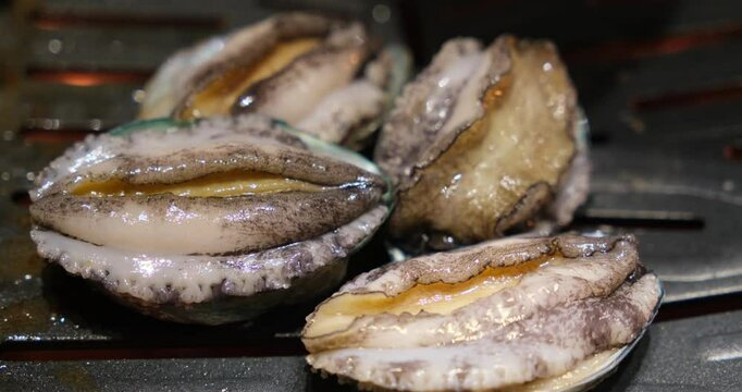close up cooking abalone seafood on barbecue grill