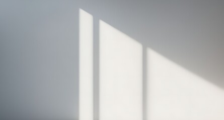 A white wall with a window in the middle. The window is letting in sunlight, creating a shadow on the wall