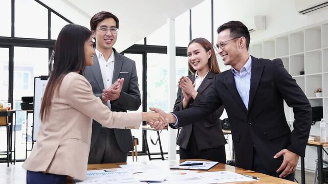 A dynamic business meeting in a modern Asian office brainstorming and cooperating. The group of colleagues is engaged in teamwork and strategic planning, leveraging technology.