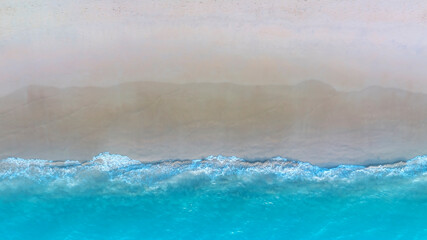 Tropical Beach with the soft wave water of the sea on the sandy beach background as texture with splashes and bubbles