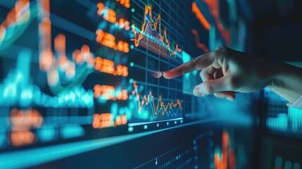 Fototapeta premium digital display showing fluctuating stock market trends, with a hand pointing at critical data, symbolizing analysis
