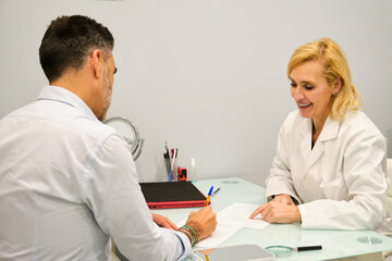 Patient man signing up the consent form in a esthetic clinic. Aesthetic doctor explaining the procedure to a patient.