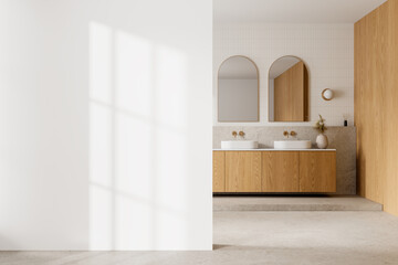 Modern bathroom interior with wooden cabinets and double sinks, large blank wall space, light and shadow effects, home decor mockup. 3D Rendering