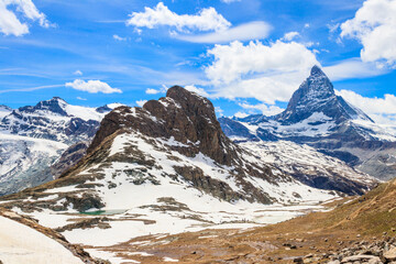 Fototapeta premium Scenic view on snowy Matterhorn mountain peak in sunny day with blue sky in Switzerland. Beautiful nature background of Swiss Alps covered with snow. Famous travel destination