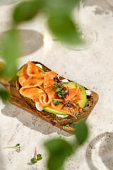Summer Sunshine Salmon and Avocado Bruschetta on Wooden Board with Shadows