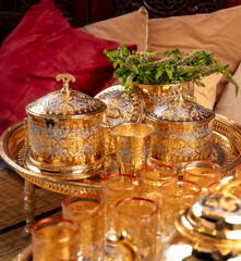 Ornate Golden Moroccan Teapots and Glasses With Dates on a Tray