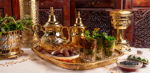 Ornate Golden Moroccan Teapots and Glasses With Dates on a Tray