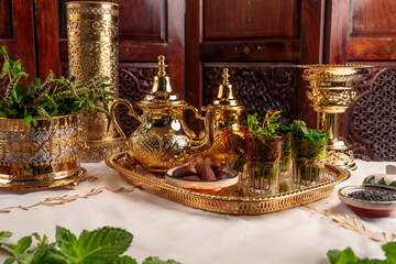Ornate Golden Moroccan Teapots and Glasses With Dates on a Tray