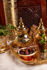 Ornate Golden Moroccan Teapots and Glasses With Dates on a Tray