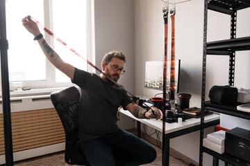 A professional photographer examines film negatives against natural light in a tidy, modern home office with photography equipment.