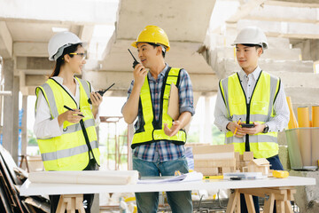 Architect Asian team working with colleagues in the construction site. Architecture engineering on big project.