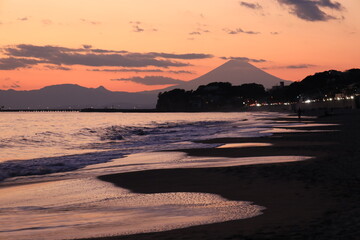 鎌倉　七里ヶ浜の海岸がオレンジ色に染まる夕景　江ノ島と富士山のシルエット