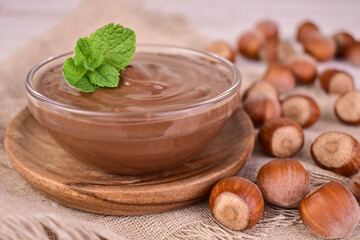 Delicious chocolate spread with hazelnut flavor on a gray background.	