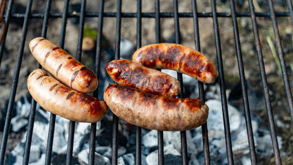 Sausages grilling on an outdoor firepit