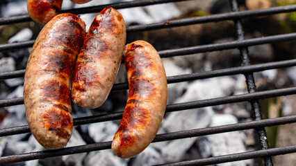 Sausages grilling on an outdoor firepit