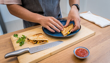 Chef at the kitchen preparing quesadillas with tofu and sweet corn
