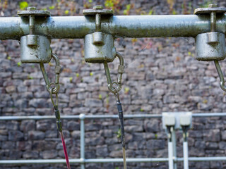 Industrial machinery close-up with metal components against a brick wall background.