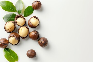 Obraz premium top view Macadamia nuts with green leaves isolated on white background