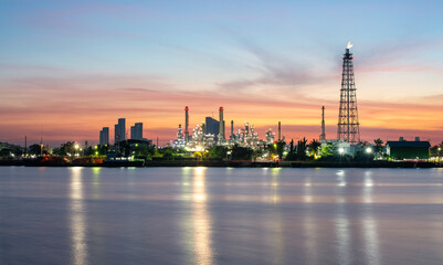 Naklejka premium Oil refinery plant industry and port, Aerial view oil and gas petrochemical industrial, Refinery factory oil storage tank and pipeline steel at night, Ecosystem and healthy environment concepts.
