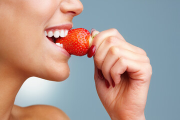 Person, mouth and eating strawberry in studio for health, wellness and detox or Vitamin C in...