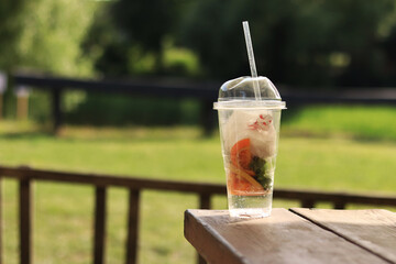 Plastic disposable cup with trash inside, close-up. Improper disposal of garbage, pollution of the...