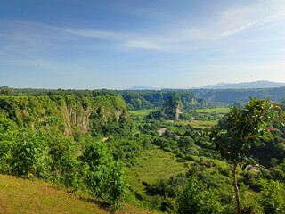 expanse of green hills and blue skies during the day, beautiful views from the top of the name Puncak Taruko Bukittinggi, Indonesia