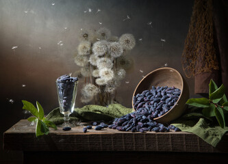 Country still life with dandelions and scattered honeysuckle on a dark background