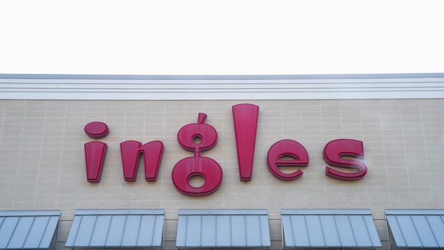 Ingles supermarket exterior sign on a beige brick wall, featuring bold red letters and a modern design.