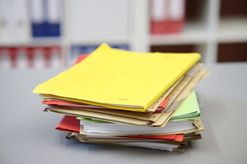 Verschiedenfarbige Akten liegend auf einem Schreibtisch, gelb