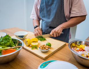 Chef at the kitchen preparing spicy glass noodle salad