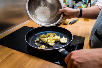 Chef at the kitchen preparing bean porridge with cauliflower and vegetables