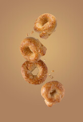 salty tarallini cookies flying on a beige background, food levitation