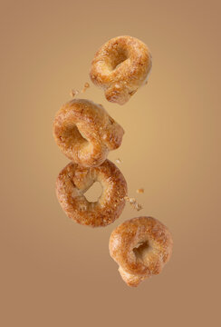 salty tarallini cookies flying on a beige background, food levitation