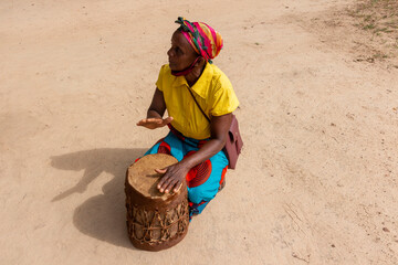 Woman Playing Traditional African Hand Drum known as Djembe or Ngoma Outdoors
