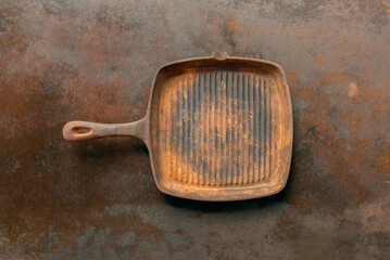 rusty cast iron grill pan on iron rustic background.