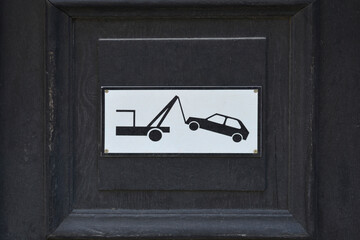 Detail of a door with a tow truck Parking enforcement sign