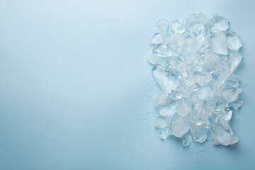 Pieces of crushed ice on light blue background, top view. Space for text