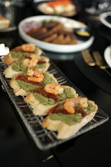 Sandwiches with sauce and shrimp on the buffet table.