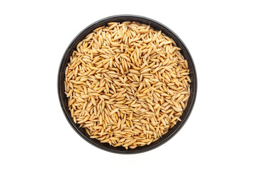 Organic Rice with Bran (Oryza sativa) or Dhaan, in a black ceramic bowl. Isolated on a white background. Top View