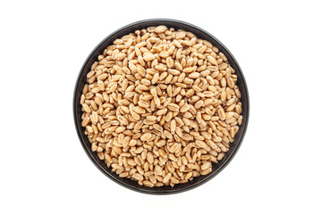 Organic Wheat Grains (Triticum) or Caryopsis Fruits, in a black ceramic bowl. Isolated on a white background. Top View