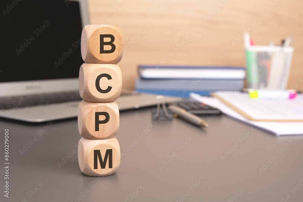 Poster text bcpm written on wooden cubes against computer keyboard background