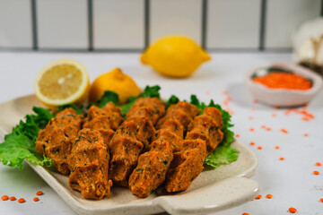 mercimek kofte, turkish lentil meatballs, vegan mediterranean food served with lemons and green salad