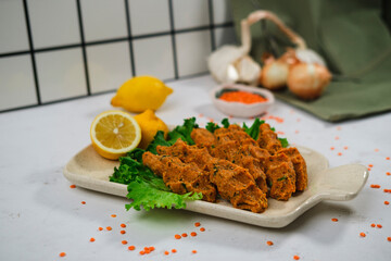 mercimek kofte, turkish lentil meatballs, vegan mediterranean food served with lemons and green salad
