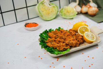 spirit of turkish traditional cuisine red lentil mercimek kofte served with lemon and green lettuce salad on white background