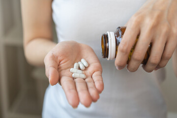 Dietary supplement or sick, asian young woman, girl hold pills, drugs medical tablet on hand...