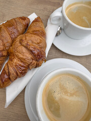 cup of coffee and croissant on table