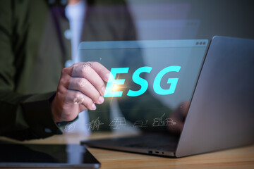 ESG environment social governance investment business concept, businessman using laptop with ESG icon.