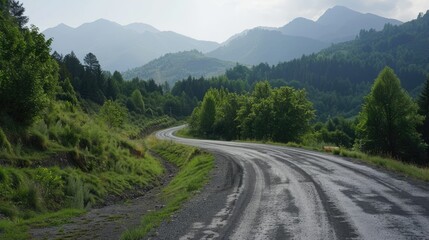 Winding asphalt road through a green forest with mountains in the horizon