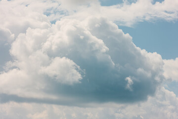 Clouds in motion create their own abstract images of a person (middle cloud) with a beard and bushy eyebrows, in the sky high above Harrington Beach State Park, Belgium, Wisconsin in mid-August